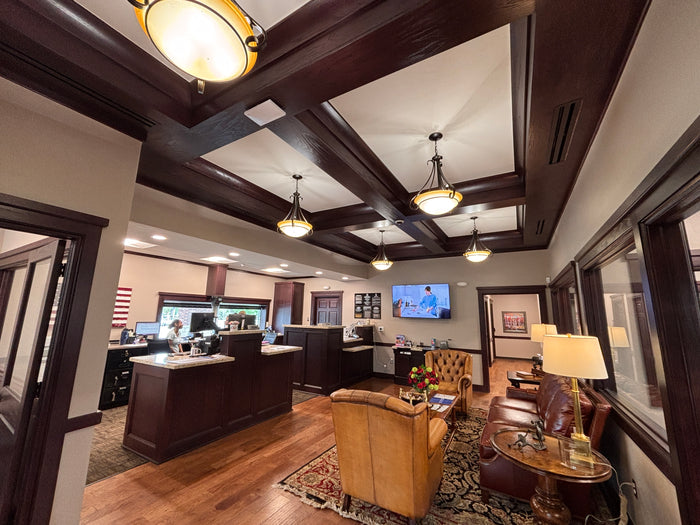 Custom teller cabinets, wood ceiling beams, and reception casework at First Fidelity Bank OKC.